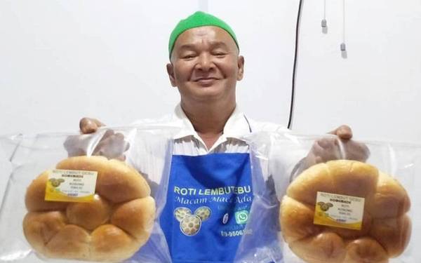 Mokhtar atau lebih mesra dengan gelaran Pok Tar bersama roti paung.