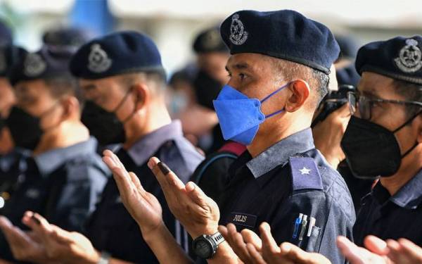 Anggota PDRM mengaminkan doa sebelum sesi pelepasan petugas Bantuan Sumber Manusia (BSM) ke daerah masing-masing, hari ini. Foto Bernama