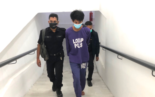 Tertuduh, Mohamad Ridzuan Hussin, 26, (tengah) dikawal ketat polis berjalan di laluan menuju ke bilik Mahkamah Sesyen Kota Bharu.