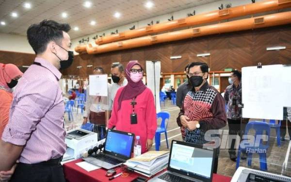 Mohd Fauzi (kanan) meninjau keadaan kaunter MPAJ yang dibuka di Dewan Datuk Ahmad Razali Kampung Melayu Ampang pada Khamis.