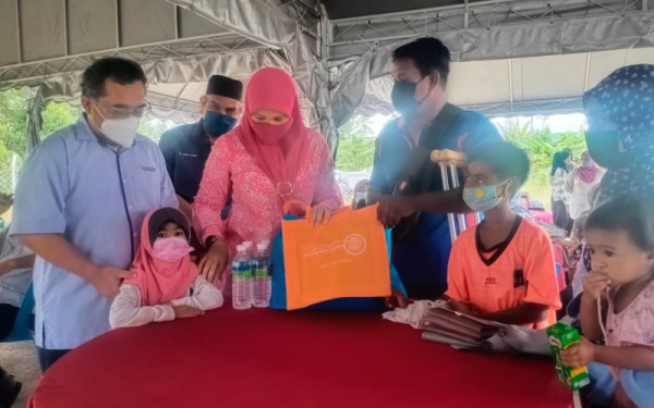 Mohd Elmi (kiri) bersama Suraya beramah mesra bersama keluarga yang menerima kemudahan menaik taraf sistem pendawaian elektrik di Sungai Tiang di sini pada Khamis.