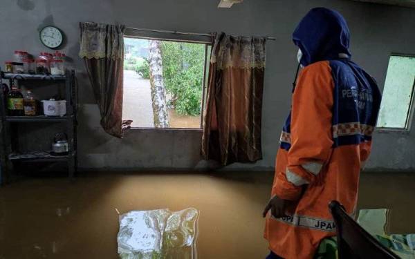 Anggota Angkatan Pertahanan Awam (APM) meninjau keadaan rumah penduduk di Kg Pamah Rawas, Raub pada Jumaat. - Foto APM