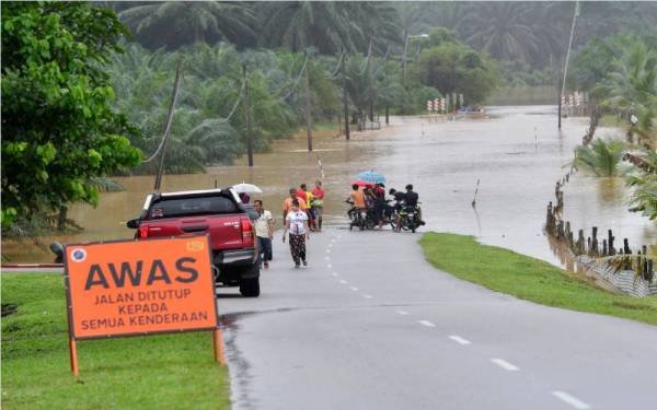 Jalan utama yang menghubungkan Kuala Nal dengan Lepan Pauh dan Bukit Sireh ditutup kepada semua kenderaan ketika tinjauan pada Sabtu. - Foto Bernama 