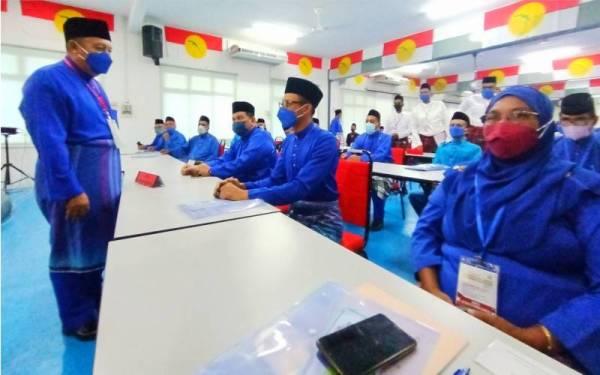 Ahmad Jazlan (kiri) beramah mesra dengan perwakilan selepas merasmikan Mesyuarat UMNO Bahagian Machang di Pusat Informasi Maklumat, Bukit Tiu, Machang pada Sabtu.