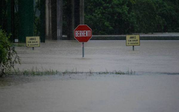 Keadaan banjir kilat akibat limpahan air dari Sungai Damansara mengakibatkan Jalan di Batu 3, Lebuhraya Persekutuan ditenggelami air dan tidak boleh dilalui oleh kenderaan. - Foto Bernama