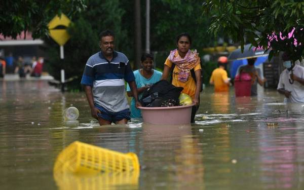 Penduduk meredah banjir dan menyelamatkan barang keperluan mereka berikutan hujan berterusan di Kampung Dengkil pada tinjauan hari ini. - Foto Bernama