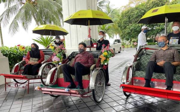 Zahidi (tengah) menaiki beca ketika menyertai menyertai Festival Peranakan Penang dan meninjau pameran Jawi Peranakan Pulau Pinang dan pameran Vintaj dan Batik Peranakan pada Ahad.