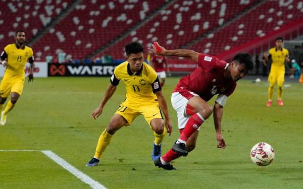 Pemain sayap Harimau Malaya, Ariff Aiman Hanapi bersaing dengan pemain Indonesia dalam aksi terakhir Kumpulan B Piala Suzuki AFF 2020 di Stadium Nasional, Singapura sebentar tadi. Foto FB FAM