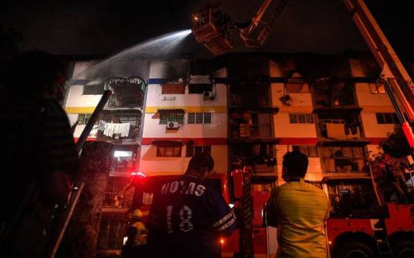 Anggota bomba memadam api kebakaran yang memusnahkan lapan rumah di tingkat empat Blok 31 Perumahan Awam Sri Johor Cheras malam ini. Foto Bernama