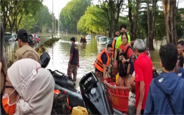 Antara mangsa terkandas yang berjaya diselamatkan dan dipindahkan dari kawasan banjir di Taman Sri Muda, di sini.