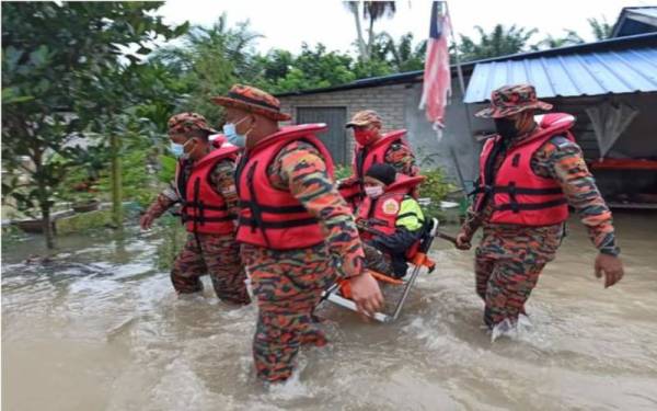 Anggota bomba membantu memindahkan mangsa banjir di Changkat Jong, Teluk Intan selepas kediaman mereka dinaiki air akibat banjir.