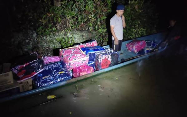 Sampan terpaksa digunakan untuk membawa bantuan kepada mangsa banjir di PPS Kg Lubuk Kulit, Lipis ekoran kawasan tersebut terkepung banjir.