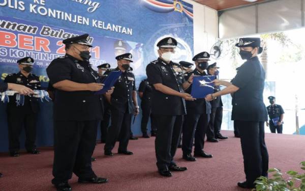 Ketua Jabatan Integriti dan Pematuhan Standard Kontinjen Kelantan, Superintendan Lee Leng Ian (kanan) antara yang menerima surat penghargaan daripada Ketua Polis Kelantan, Datuk Shafien Mamat pada Perhimpunan Bulanan PDRM Kontinjen Kelantan pada Isnin.