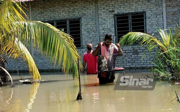 Mohd Shahrizan sanggup meredah banjir untuk memberi kucing-kucingnya makan selepas kediamannya di Kampung Batu 8, Lorong Kedah, Changkat Jong dinaiki air.