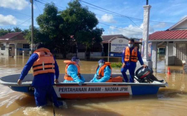 Anggota Angkatan Pertahanan Awam (APM) menggerakkan operasi membantu memindahkan mangsa banjir di Taman Seri Desa, Kuala Krau, Temerloh. - Foto Ihsan APM Pahang