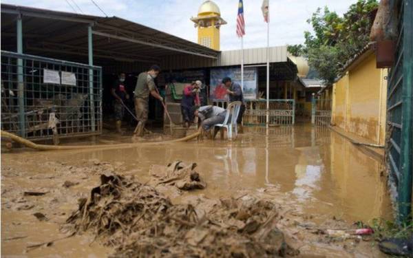 Penduduk membersihkan Masjid Al-Ehsan Kampung Sungai Serai di Hulu Langat selepas banjir mulai surut ketika tinjauan pada Isnin. - Foto Bernama
