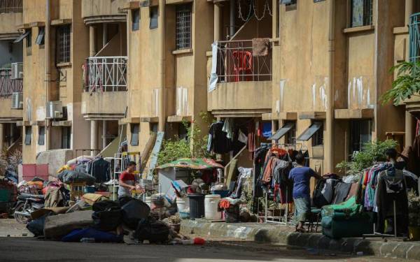 Penduduk Pangsapuri Perdana membersihkan kelengkapan rumah yang rosak dan diselaputi lumpur selepas kediaman mereka dinaiki air ketika tinjauan di Seksyen 13 pada Isnin. - Foto Bernama