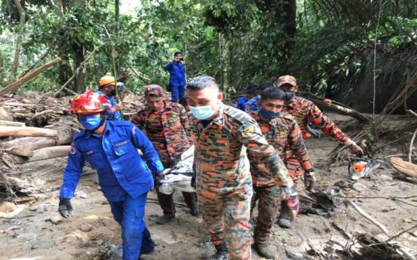 Anggota bomba dan Angkatan Pertahanan Awam (APM) membantu membawa mayat mangsa tragedi banjir lumpur melanda sebuah chalet di Bentong yang ditemui pada pagi Selasa.