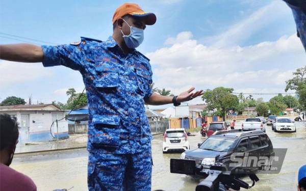 Che Adam meninjau sitausi semasa air banjir di Taman Perumahan Cenderawasih pada Selasa.