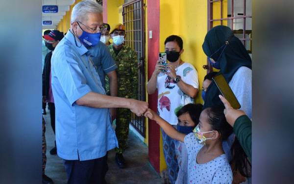 Ismail Sabri beramah mesra dengan golongan kanak-kanak semasa menyantuni semua mangsa banjir yang ditempatkan di Pusat Pemindahan Sementara (PPS) Sekolah Kebangsaan Sri Buntar, pada Selasa. - Foto Bernama