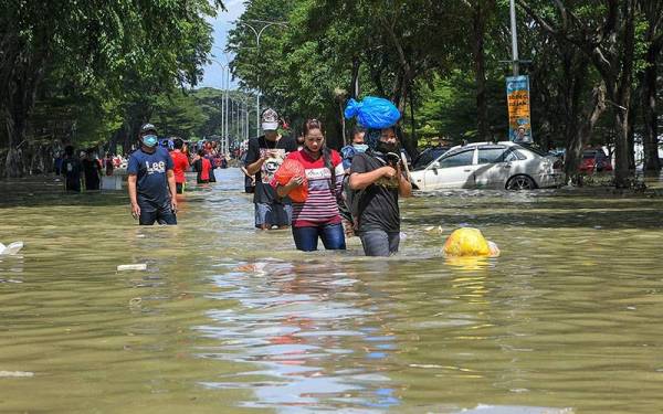 Mangsa-mangsa banjir di Taman Seri Muda Seksyen 25 mengambil barang keperluan berikutan banjir yang masih belum surut sepenuhnya pada Selasa. - Foto Bernama