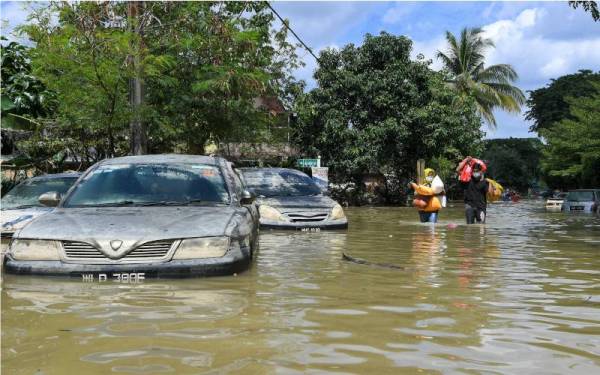 Mangsa-mangsa banjir di Taman Seri Muda Seksyen 25 mengambil barang keperluan berikutan banjir yang masih belum surut sepenuhnya pada Selasa. - Foto Bernama 