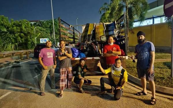 Mohd Sahril (duduk, hadapan) bersama rakan yang membantu misi bantuan mangsa banjir di Selangor.