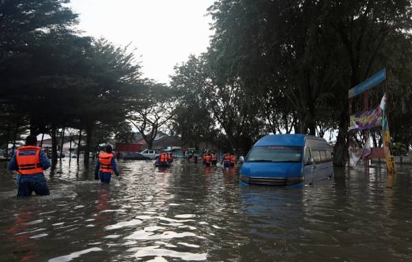 Anggota Angkatan Pertahanan Awam Malaysia (JBPM) meredah air untuk memberi bantuan kepada mangsa banjir ketika tinjauan di Taman Sri Muda Seksyen 25 Shah Alam. -Foto Bernama