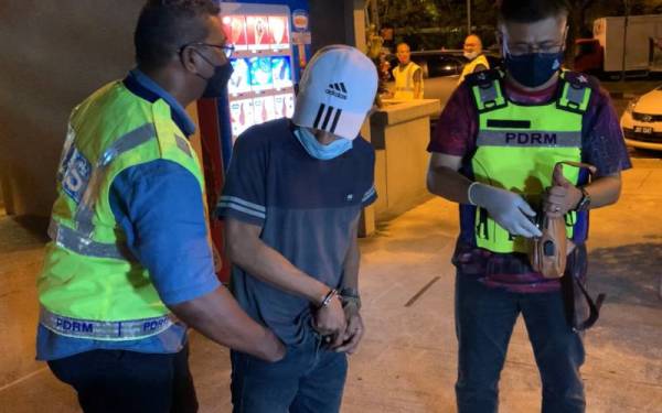 Lelaki berusia 42 tahun (tengah) diperiksa anggota polis selepas disahkan positif dadah jenis methamphetamine dalam operasi bersepadu di RNR Simpang Renggam arah Utara, Kluang pada Selasa.