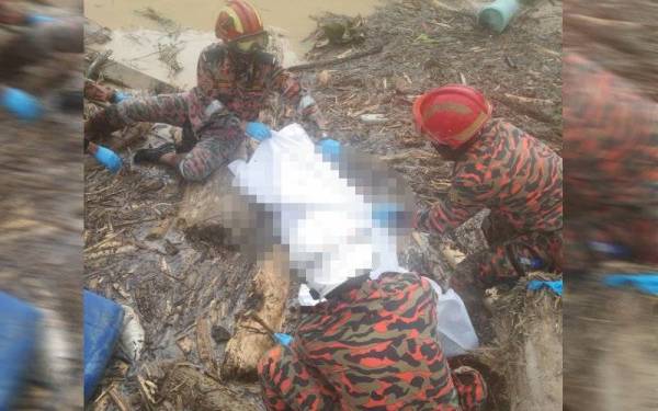 Anggota bomba membantu mengangkat mayat Emmanuel Chang Li Zheng, 6, yang ditemukan di bawah timbunan kayu pada Rabu.