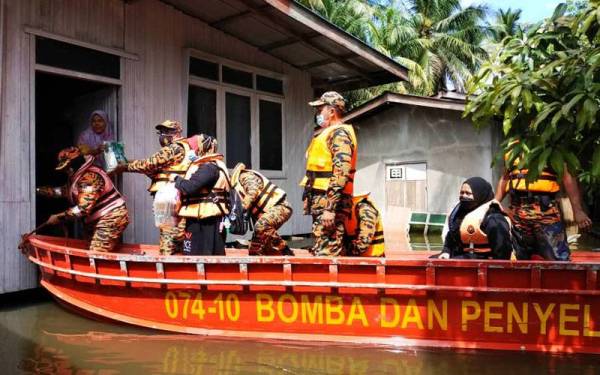 Zainun dari Kampung Padang Licin, Rantau Panjang mengukir senyuman sejurus melihat kehadiran sekumpulan anggota bomba menghampiri rumahnya yang ditenggelami banjir sejak Jumaat lalu.