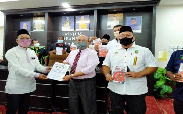 Izam Jamiri (kiri) menyerahkan memorandum kepada Zulqarnain di Bangunan MPKK, di sini pada Rabu.