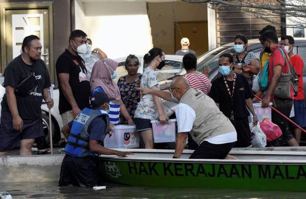 SHAH ALAM, Dec 21 - Nadma director-general Datuk Dr Aminuddin Hassim distributing food aid to flood victims after a press conference at Taman Sri Muda, Seksyen 25, Shah Alam, Selangor. (Source: Bernama)