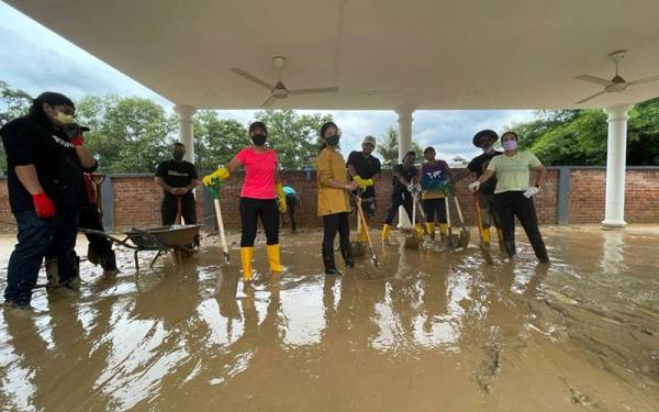 Nina (empat dari kiri) bersama sukarelawan membantu penduduk membersihkan rumah yang dilanda banjir.