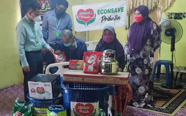 Zamzuri (kiri) menyerahkan sumbangan Econsave Prihatin kepada Mohd Khobil (tiga kiri) di Kampung Kubang Besar, Pokok Sena pada Rabu. Turut kelihatan Norzamila (kanan).