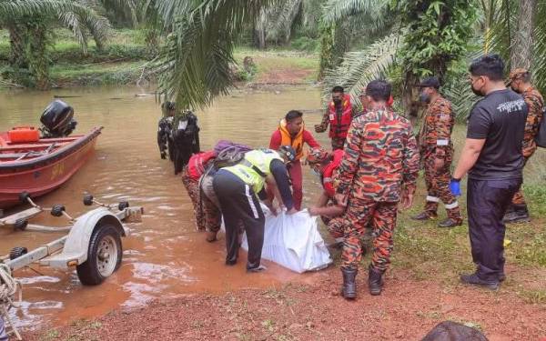 Anggota bomba membantu mengangkat mayat mangsa sebelum diserahkan keada pihak polis sebelum dihantar ke Hospital Pekan untuk proses bedah siasat.