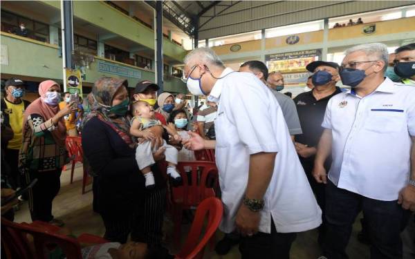 Ismail Sabri meluangkan masa bertanya khabar mangsa-mangsa banjir yang terjejas akibat banjir di PPS Sekolah Kebangsaan Bukit Piatu pada Jumaat. - Foto Bernama 