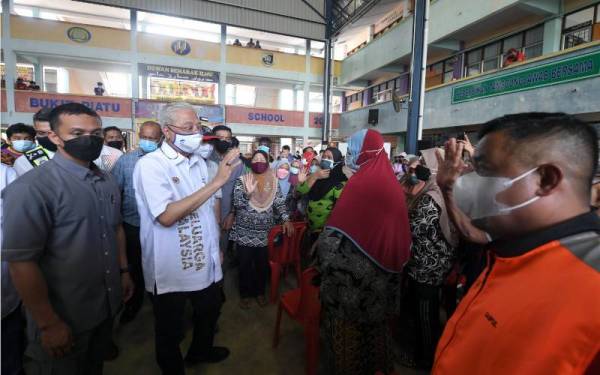 Ismail Sabri meluangkan masa bertanyakan khabar mangsa-mangsa banjir yang terjejas akibat banjir di Pusat Pemindahan Sementara (PPS) di Sekolah Kebangsaan Bukit Piatu pada Jumaat. - Foto Bernama 