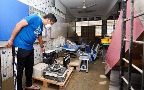 Mohd Radzi membuat tinjauan ke sekolah terjejas banjir. Foto: FB Dr Radzi Jidin