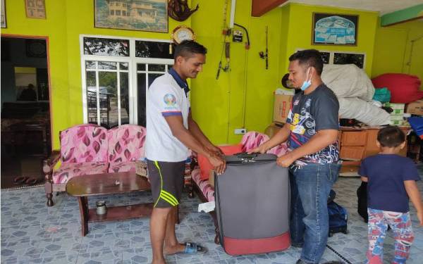 Azhar (kanan) sibuk mengemaskan kediaman bapa mertuanya di Kampung Bestari Jaya, Kuala Selangor, pada Sabtu.