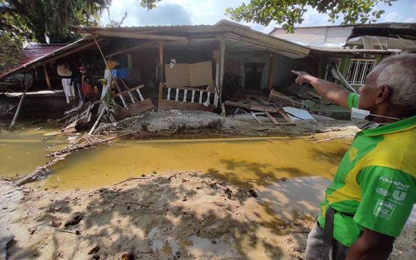 Mohd Yusof menunjukkan struktur rumahnya yang runtuh akibat banjir besar di Kampung Bestari Jaya, Kuala Selangor.