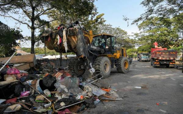 Kerja-kerja pembersihan barangan rumah yang telah rosak akibat banjir sedang giat dilakukan ketika tinjauan di sekitar Taman Sri Muda Seksyen 25 hari ini. -Foto Bernama