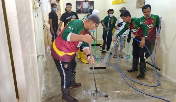 Wan Sukhairi (kiri) bersama NGO Khidmat Malaysia Terengganu membersihkan rumah penduduk di Perumahan Awam Kos Rendah Bukit Rangin.