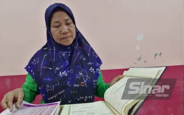 Raja Hasnah menunjukkan al-Quran miliknya yang tidak terkesan ketika banjir pada 18 Disember lalu.