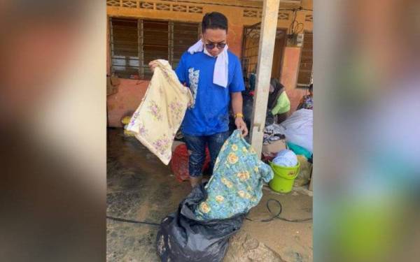 Khairul Nizam menunjukkan dua bantal busuk disumbangkan orang ramai kepada mangsa banjir.