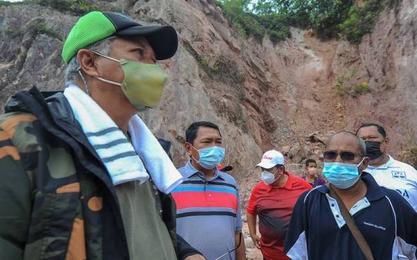 Annuar (kiri) ketika turun padang agihkan bantuan makanan dan keperluan harian kepada masyarakat Orang Asli Suku Temuan dari Kampung Orang Asli Tadom, Paya Rumput dan Mutus Tua yang masih ditenggelami air pada Program Prihatin Menteri Komunikasi dan Multimedia Bersama Mangsa Banjir Sepang di penempatan sementara Orang Asli Tadom hari ini. - Foto Bernama