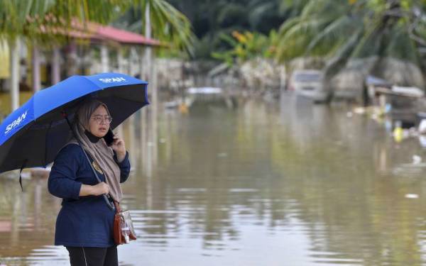 Mangsa banjir, Azlimi Ayub, 40, melahirkan perasaan bimbang ekoran banjir tidak surut walaupun telah melalui cuaca panas selama dua hari di kawasan Kampung Seri Tanjung. Gambar diambil pada 22 Disember lalu. - Foto Bernama