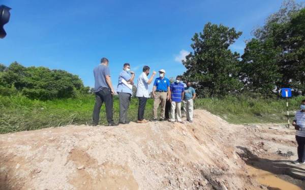 Abd Rahim (tiga dari kanan) pada Selasa meninjau tebing yang terhakis punca perumahan Taman Makmur Mahkota, Kuantan dinaiki air.