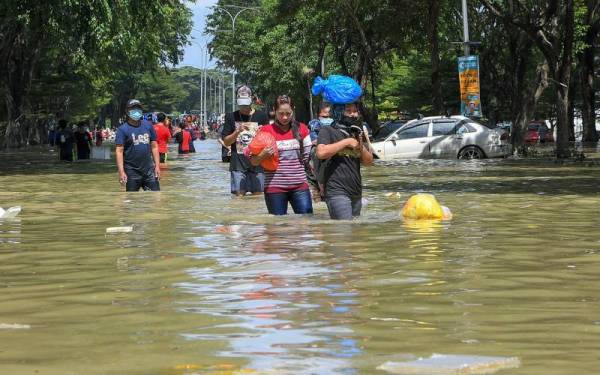 Mangsa-mangsa banjir di Taman Seri Muda Seksyen 25 mengambil barang keperluan berikutan banjir yang masih belum surut sepenuhnya. Gambar diambil pada 21 Disember lalu. - Foto Bernama