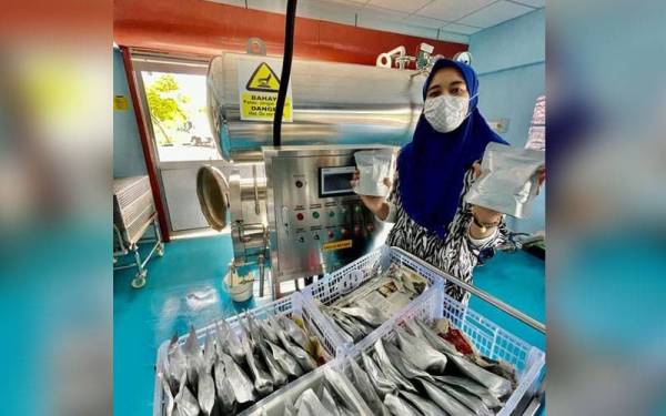 Farhana menunjukkan makanan disumbang disimpan menggunakan mesin retort di MARA Halal Park, Kuala Perlis, Kangar di sini.